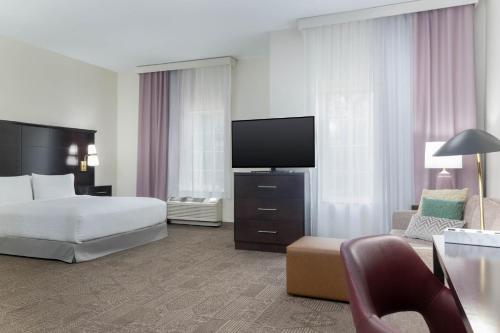 um quarto de hotel com uma cama e uma TV de tela plana em Staybridge Suites Chandler by IHG em Chandler