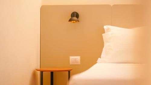 a bedroom with a bed with a light switch and a table at Hotel Theatro- City Center in Tirana