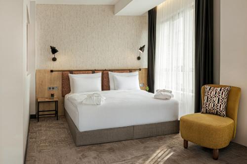 エスキシェヒルにあるSmart By Pointのベッドと椅子のある寝室