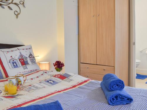Un dormitorio con una cama con toallas azules. en The Cabin, en Pevensey