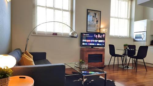 a living room with a couch and a tv at Notting Hill- The One One One! -5- in London