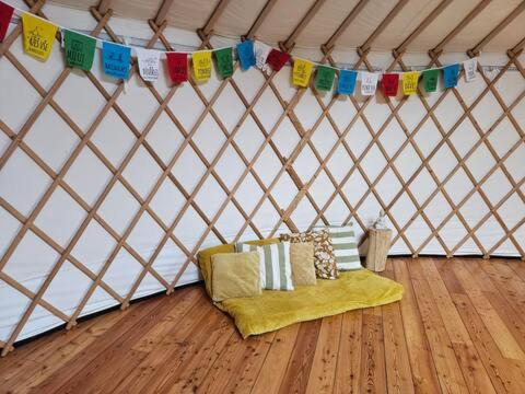 a tent with a couch in a room with flags at Jurta na Souvrati 