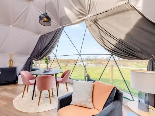 Zimmer mit einem Zelt mit einem Tisch und Stühlen in der Unterkunft The Dome in Glasson