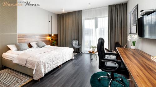 Un dormitorio con una cama y un escritorio con una silla. en Wonder Hill - bajkowy widok na góry i zalew, dostęp do basenów i jacuzzi, en Sosnówka