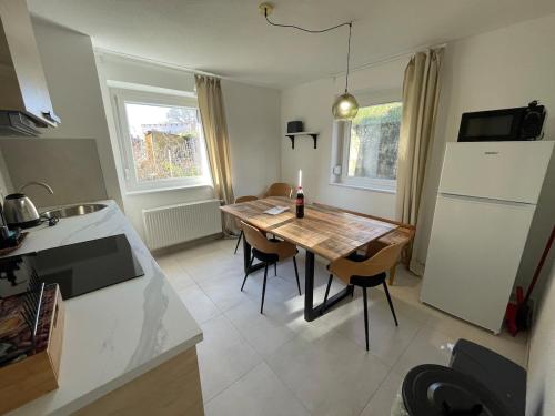 une cuisine avec une table avec des chaises et un réfrigérateur dans l'établissement Stilvolles Apartment,3SZ,Einzelbetten,Legoland,Ulmer Münster,bis6P, à Blaustein