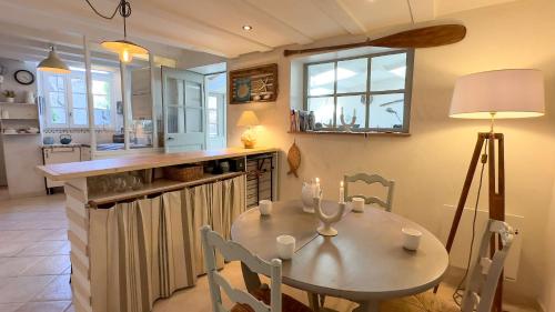 a kitchen with a table with chairs and a counter at Charmante villa dans le centre village in Ars-en-Ré