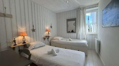 a room with two beds and a window at Charmante villa dans le centre village in Ars-en-Ré