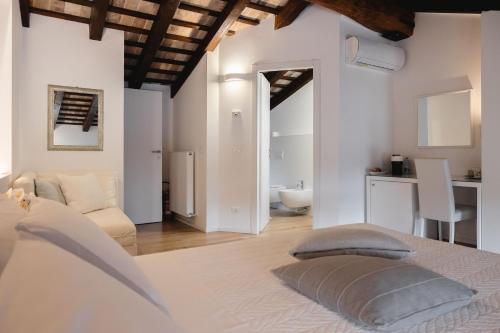 a white bedroom with a bed and a bathroom at Affittacamere CASA DOLCE CASA SAN DANIELE in San Daniele del Friuli