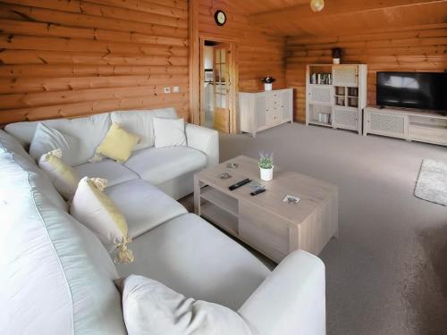 a living room with a white couch and a tv at The Lodge in Storrington
