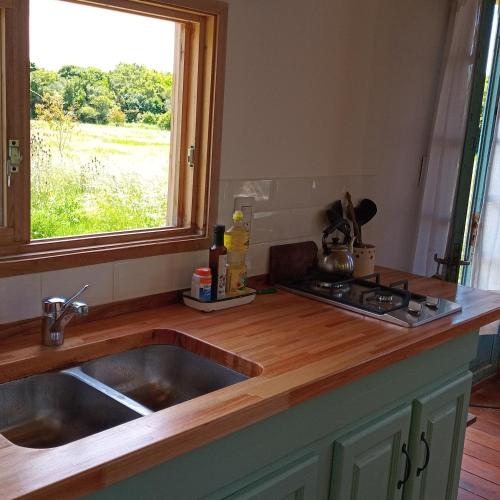 a kitchen counter with a sink and a window at Cabaña entre molles in Punta Indio