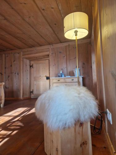 una habitación con una mesa con una lámpara y un objeto blanco en Patrizer Haus in Bergbauerndorf, en Cazis