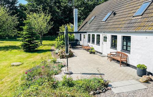 a house with a patio with benches in front of it at 2 Bedroom Beautiful Home In Bogense in Bogense