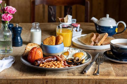 una mesa de desayuno con una bandeja de alimentos para el desayuno en The Pelican Inn, en Froxfield