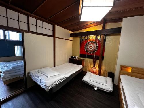 um pequeno quarto com duas camas e uma janela em Artist Village Apartments Kochi em Kochi