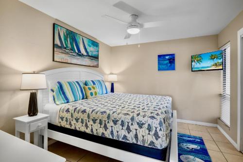 a bedroom with a bed and two paintings on the wall at Midnight Cove II 111F in Siesta Key