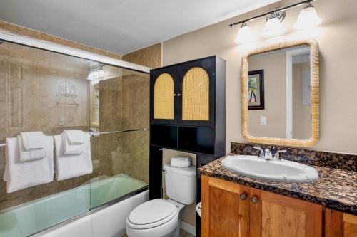 a bathroom with a sink and a toilet and a tub at Midnight Cove II 111F in Siesta Key