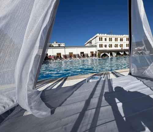 a shadow of a person taking a picture of a swimming pool at TEA Prizren Hotel in Prizren