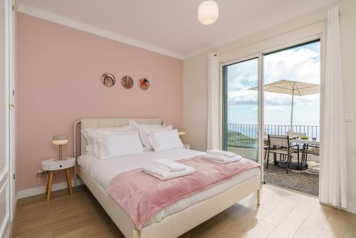 una camera da letto con un letto con vista sull'oceano di Villa Pargo Green by Madeira Dream Stays a Ponta do Pargo