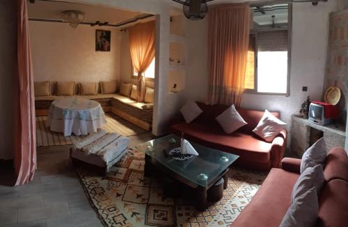 un soggiorno con un divano e un tavolo di MountainHouse- cozy and spacious family triplex a Midelt