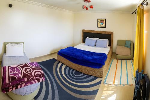 a small bedroom with a bed and a chair at MountainHouse- cozy and spacious family triplex in Midelt