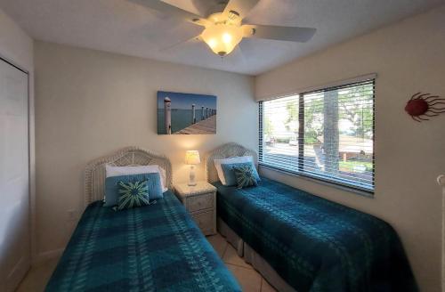 a bedroom with two beds and a ceiling fan at Midnight Cove II 128F in Siesta Key