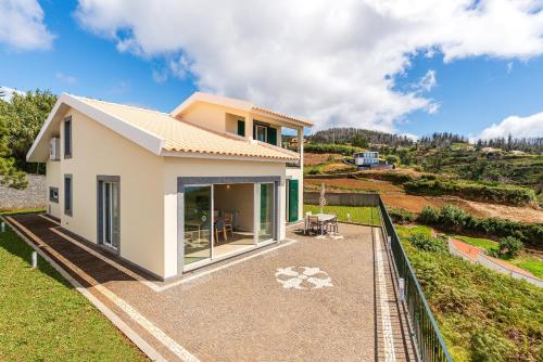 a small white house on top of a hill at Villa Pargo Green by Madeira Dream Stays in Ponta do Pargo