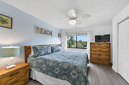 a bedroom with a bed and a dresser and a tv at Midnight Cove II 138F in Siesta Key