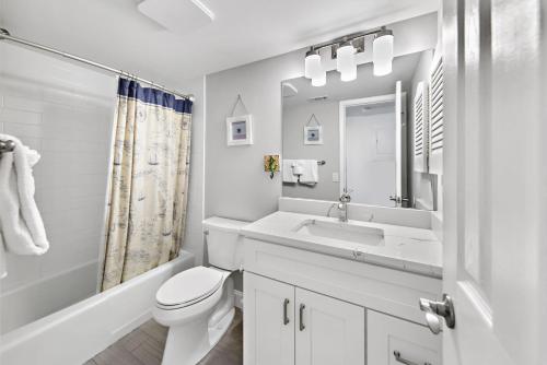 a white bathroom with a sink and a toilet at Midnight Cove II 138F in Siesta Key