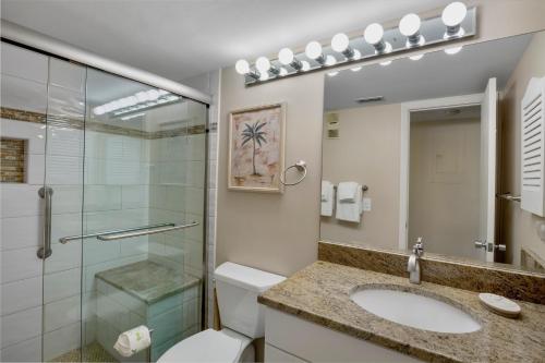 a bathroom with a toilet sink and a glass shower at Midnight Cove II 213F in Siesta Key