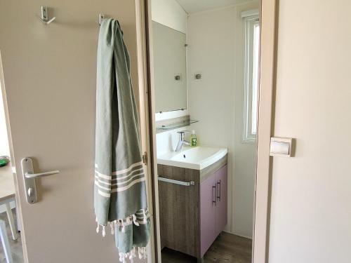 - Baño con lavabo y toalla en De Pujol Greenchalets Argeles sur Mer, en Argelès-sur-Mer