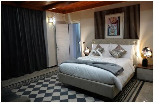 a bedroom with a large bed and a checkered floor at Hotel Villa Nunziante Pompei in Scafati