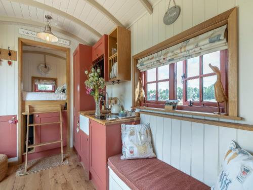 a kitchen with pink and white cabinets and a sink at Bonnie's Shepherd Hut - Uk50228 in Nottingham