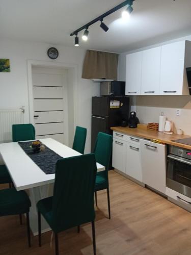 a kitchen with a white table and green chairs at Arónia in Piešťany