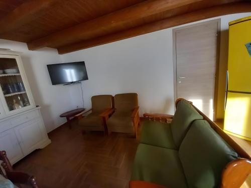 ein Wohnzimmer mit Couch und Fernseher in der Unterkunft Domo Clelia in Nulvi