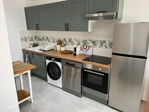 a kitchen with green cabinets and a washer and dryer at Maison idéale famille, 6 pers - Disney 15 min in Quincy-Voisins
