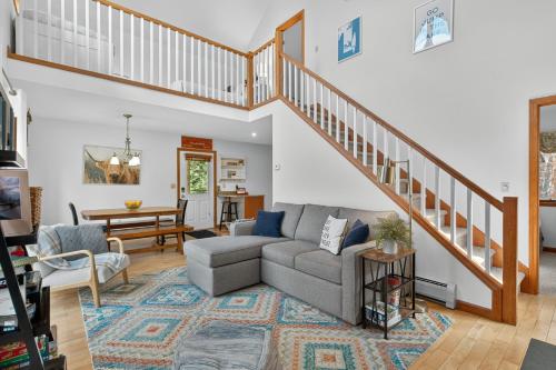 a living room with a couch and a staircase at VT Lake house minutes from Okemo in Ludlow