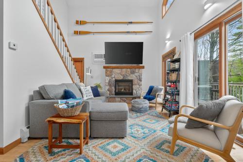 a living room with two chairs and a fireplace at VT Lake house minutes from Okemo in Ludlow
