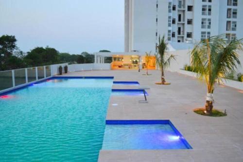 ein großer Pool in einem Gebäude mit Palmen in der Unterkunft Espacio Confortable y Agradable, Atlantis in Santa Cruz de la Sierra