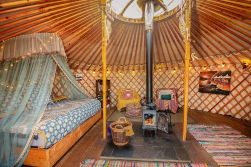 Zimmer mit einem Bett und Stühlen in einer Jurte in der Unterkunft Finest Retreats - Pandy Traditional Yurt in Penmaen Pool