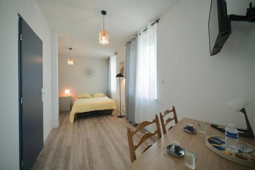 a room with a bed and a table with a dining room at Confortable Studio in Mulhouse