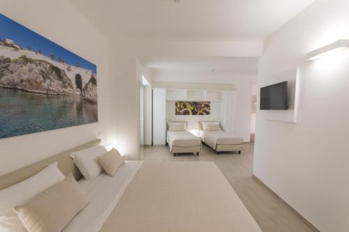 a white living room with a couch and a tv at Est hotel in Santa Cesarea Terme