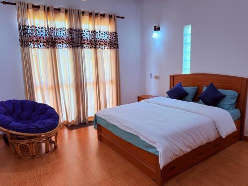 a bedroom with a bed and a chair at Transit villa 10 minutes drive from the Airport in Katunayake