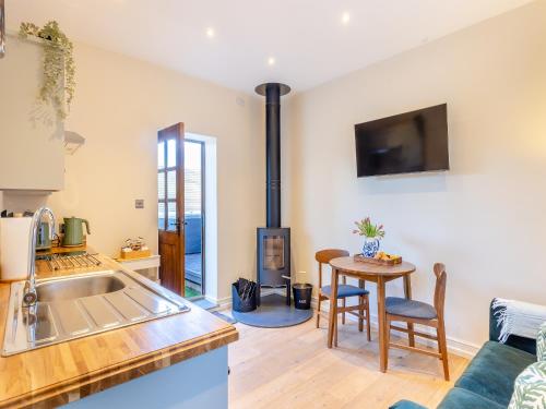 a kitchen and living room with a stove at Rose Cottage - Uk45497 in Great Budworth