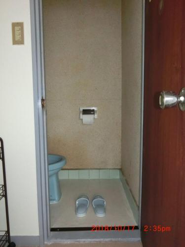 a bathroom with a toilet and a pair of slippers at YabFarm Lodge 101 in Kashiwa