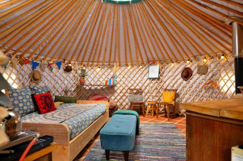 ein Schlafzimmer in einer Jurte mit einem Bett und Stühlen in der Unterkunft Finest Retreats - Pandy Mongolian Yurt in Penmaen Pool