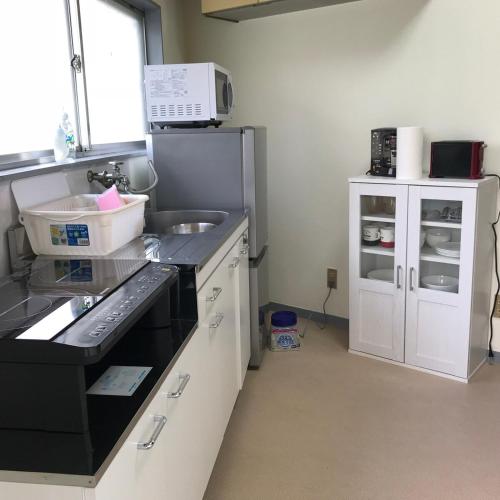 a kitchen with a sink and a refrigerator at YabFarm Lodge 101 in Kashiwa