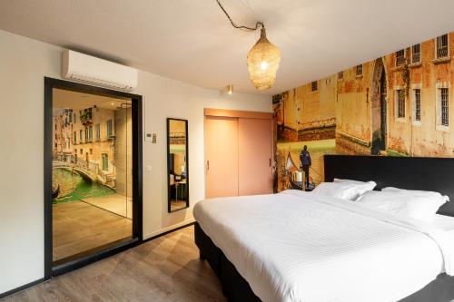 a bedroom with a large white bed and a window at Boutique Hotel de Statie in Valkenswaard