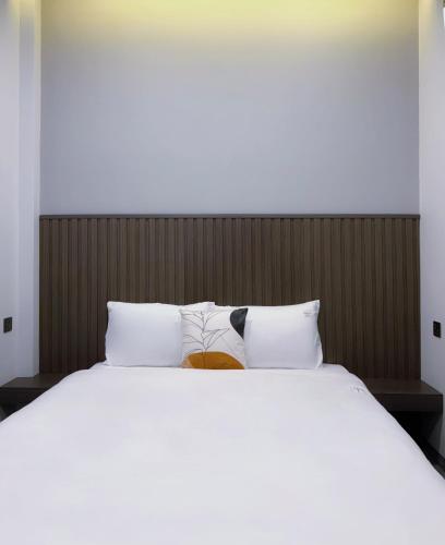 a bed with two pillows and a book on it at Lin Hotel and Coffee in Hòa Bình