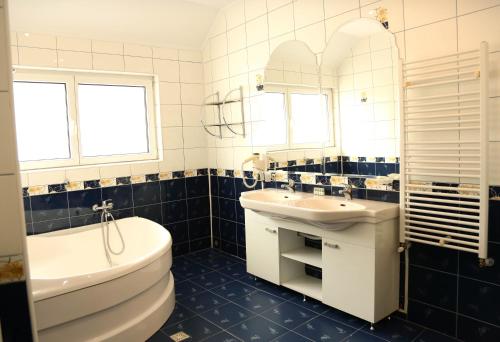 a bathroom with a sink, toilet and bathtub at Hotel Apollonia in Braşov