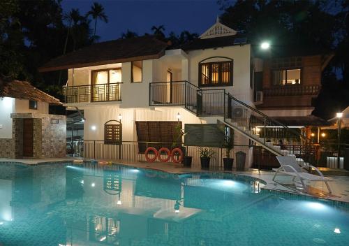 une piscine devant une maison la nuit dans l'établissement Mangrove Heritage Home, Chendamangalam, à Cochin